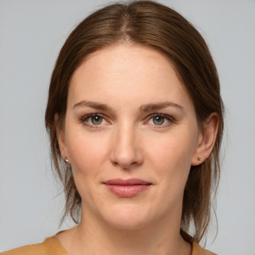 Joyful white young-adult female with medium  brown hair and grey eyes