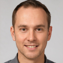 Joyful white young-adult male with short  brown hair and brown eyes