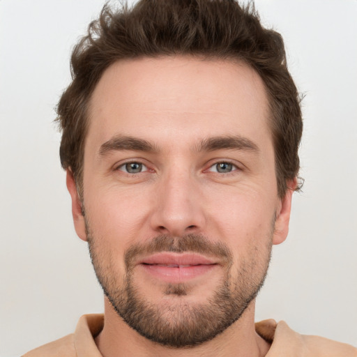 Joyful white young-adult male with short  brown hair and grey eyes