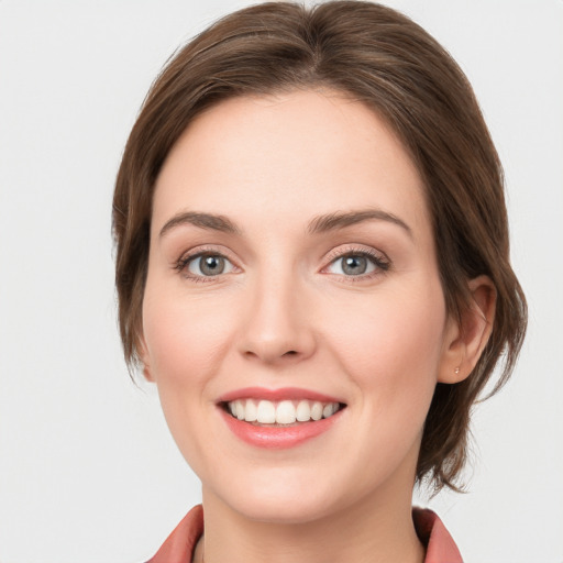 Joyful white young-adult female with medium  brown hair and blue eyes