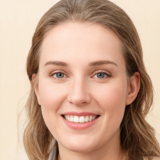 Joyful white young-adult female with long  brown hair and blue eyes