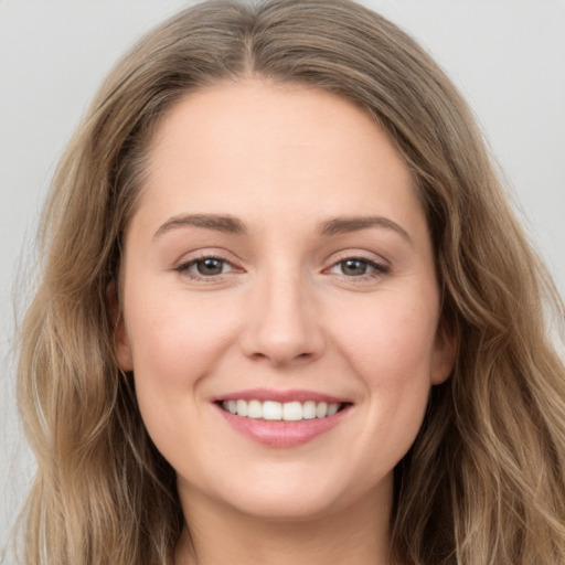 Joyful white young-adult female with long  brown hair and grey eyes