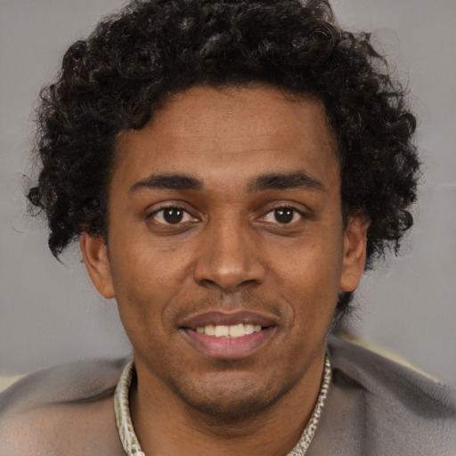 Joyful black young-adult male with short  brown hair and brown eyes