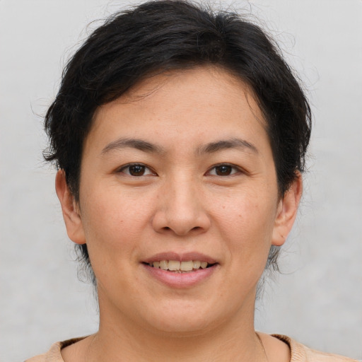 Joyful asian adult female with short  brown hair and brown eyes