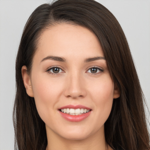 Joyful white young-adult female with long  brown hair and brown eyes