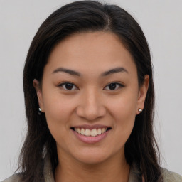 Joyful latino young-adult female with long  brown hair and brown eyes