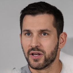 Joyful white young-adult male with short  black hair and brown eyes