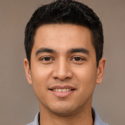 Joyful latino young-adult male with short  brown hair and brown eyes