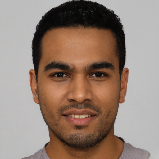 Joyful latino young-adult male with short  black hair and brown eyes