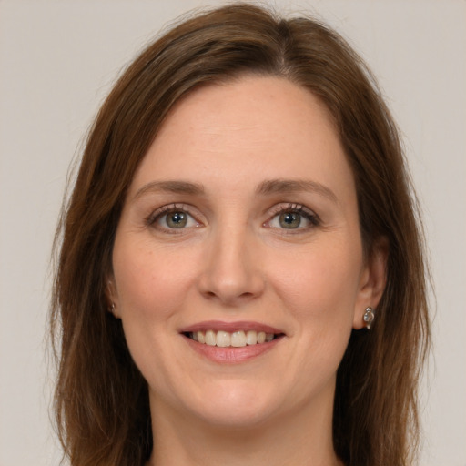 Joyful white young-adult female with long  brown hair and green eyes