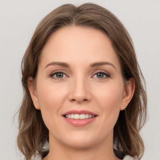 Joyful white young-adult female with medium  brown hair and grey eyes