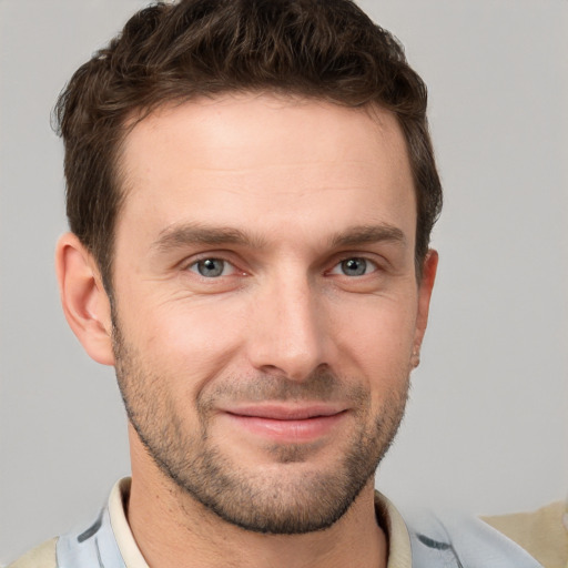 Joyful white young-adult male with short  brown hair and grey eyes