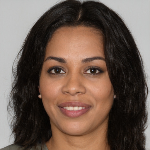 Joyful black young-adult female with long  black hair and brown eyes