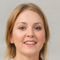 Joyful white young-adult female with medium  brown hair and blue eyes