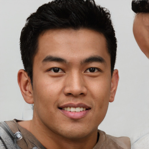 Joyful black young-adult male with short  brown hair and brown eyes