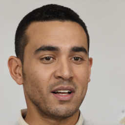 Joyful latino young-adult male with short  black hair and brown eyes