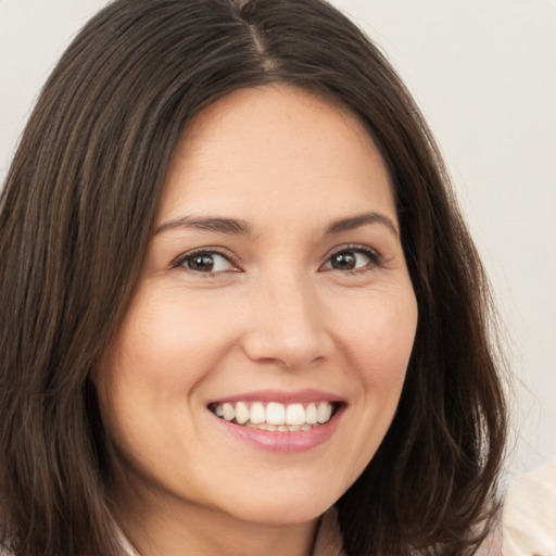 Joyful white young-adult female with long  brown hair and brown eyes