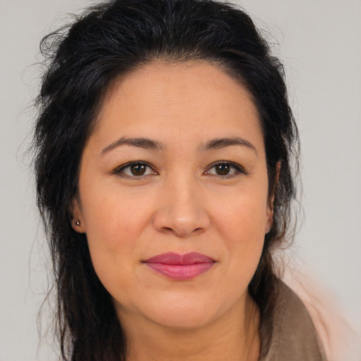 Joyful latino adult female with long  brown hair and brown eyes
