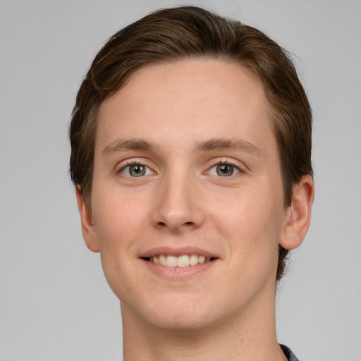 Joyful white young-adult male with short  brown hair and green eyes