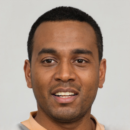 Joyful black young-adult male with short  black hair and brown eyes