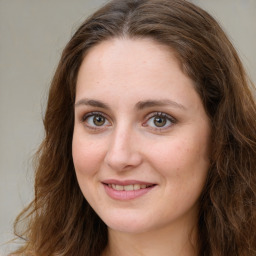 Joyful white young-adult female with long  brown hair and green eyes