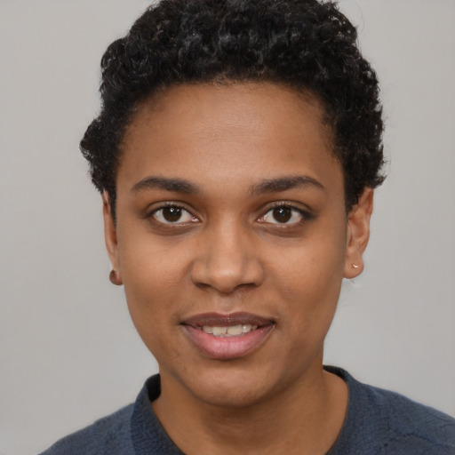 Joyful black young-adult female with short  black hair and brown eyes