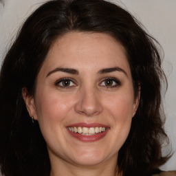 Joyful white adult female with long  brown hair and brown eyes