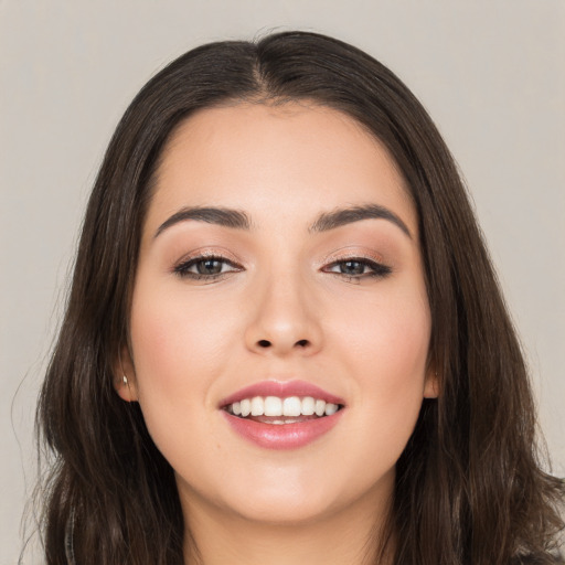 Joyful white young-adult female with long  brown hair and brown eyes