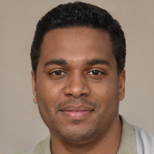 Joyful black young-adult male with short  black hair and brown eyes