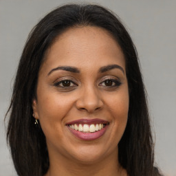 Joyful latino young-adult female with long  brown hair and brown eyes