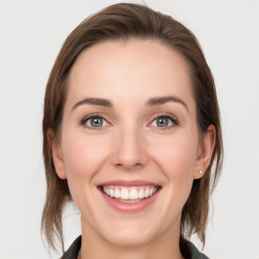 Joyful white young-adult female with medium  brown hair and blue eyes