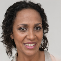 Joyful latino adult female with medium  brown hair and brown eyes