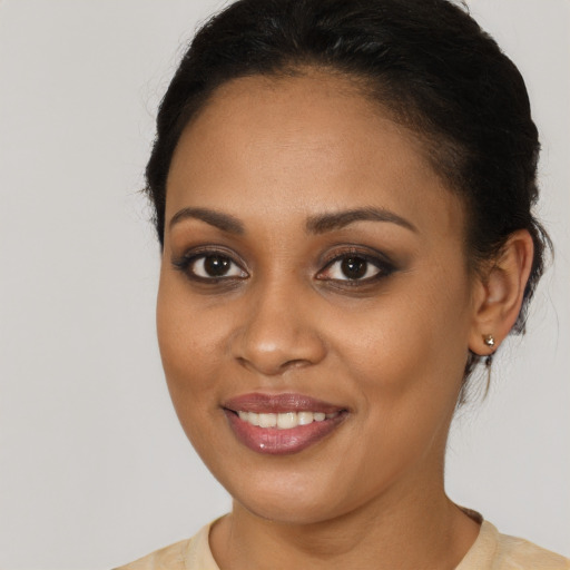 Joyful black young-adult female with long  brown hair and brown eyes