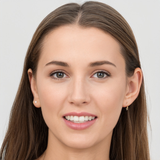 Joyful white young-adult female with long  brown hair and grey eyes