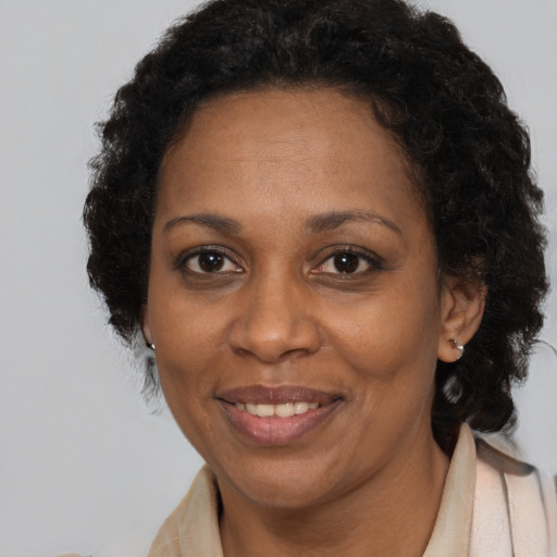 Joyful black adult female with long  brown hair and brown eyes