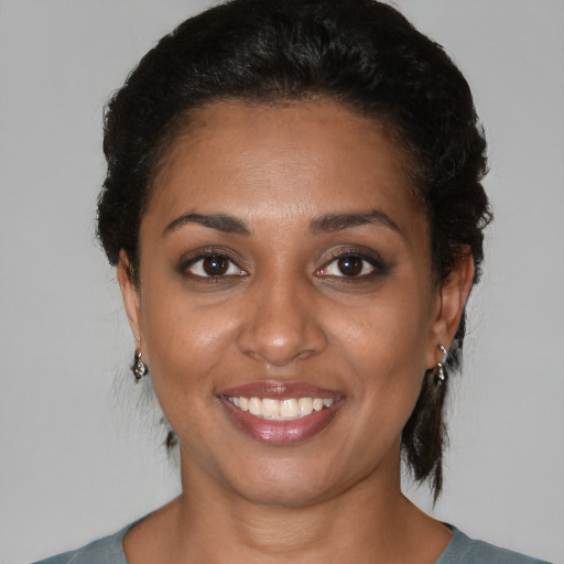 Joyful black young-adult female with short  brown hair and brown eyes