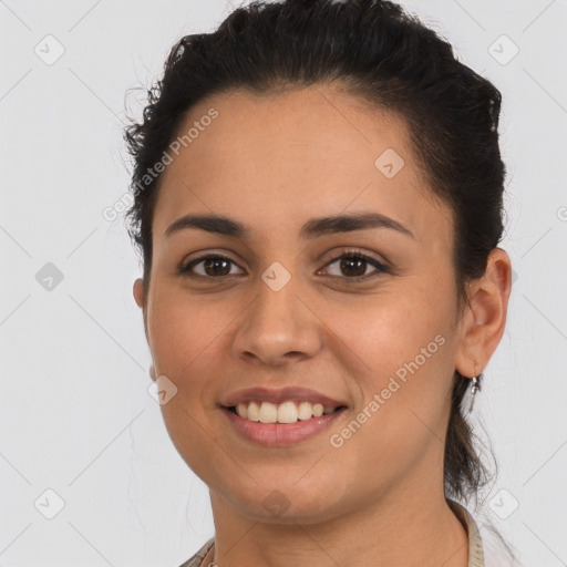 Joyful latino young-adult female with long  brown hair and brown eyes