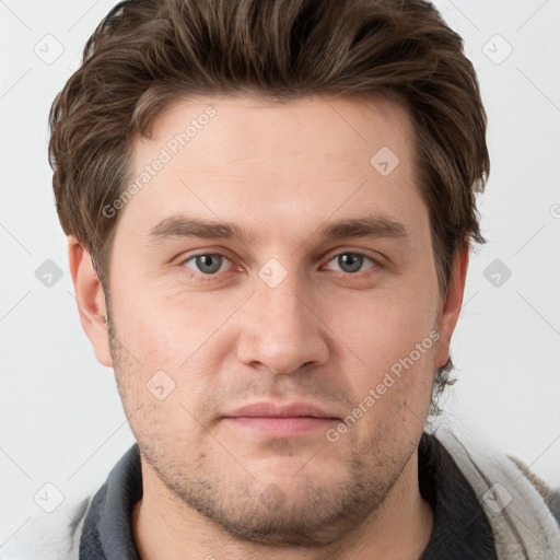 Joyful white young-adult male with short  brown hair and grey eyes