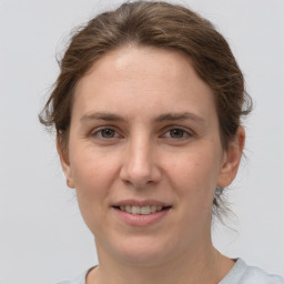 Joyful white young-adult female with medium  brown hair and grey eyes