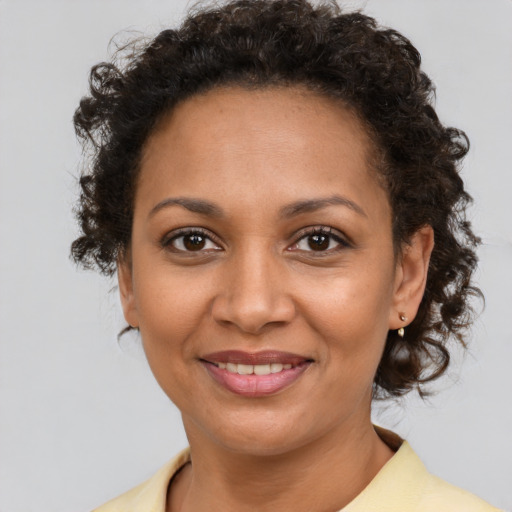 Joyful black young-adult female with medium  brown hair and brown eyes