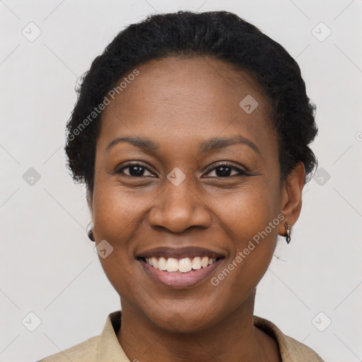 Joyful black young-adult female with short  black hair and brown eyes