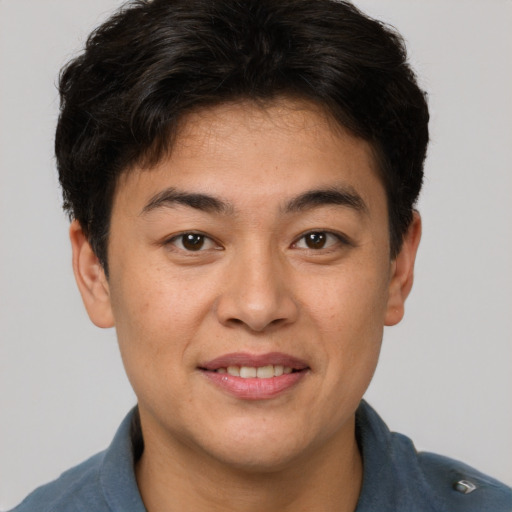 Joyful asian young-adult male with short  brown hair and brown eyes