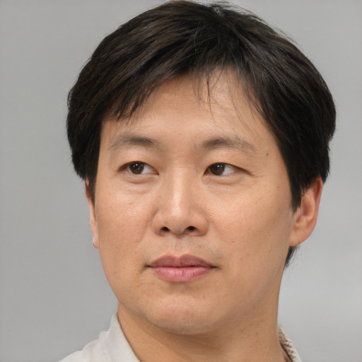 Joyful asian adult male with short  brown hair and brown eyes