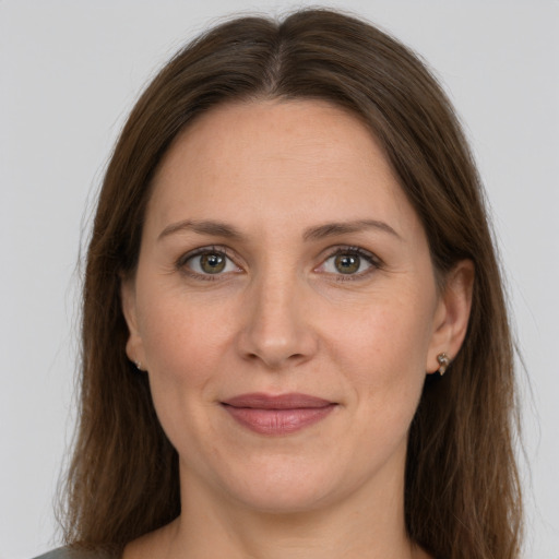 Joyful white adult female with long  brown hair and grey eyes