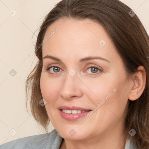 Joyful white adult female with medium  brown hair and grey eyes