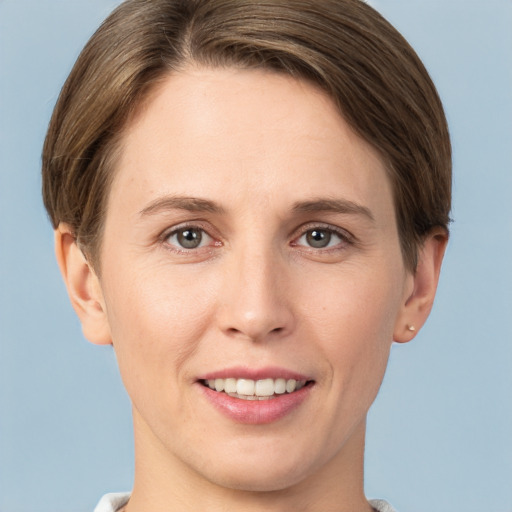 Joyful white young-adult female with short  brown hair and grey eyes