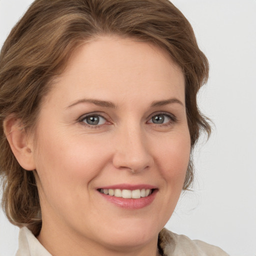 Joyful white young-adult female with medium  brown hair and green eyes