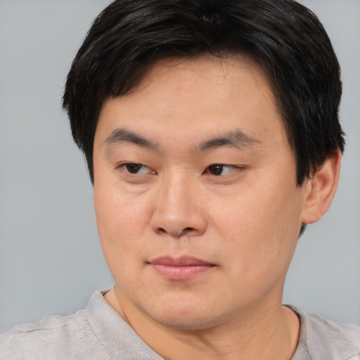 Joyful asian young-adult male with short  brown hair and brown eyes