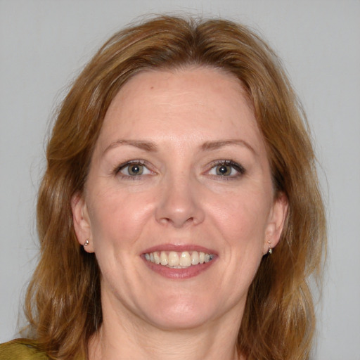 Joyful white adult female with medium  brown hair and blue eyes