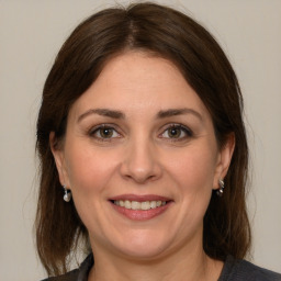 Joyful white adult female with medium  brown hair and grey eyes